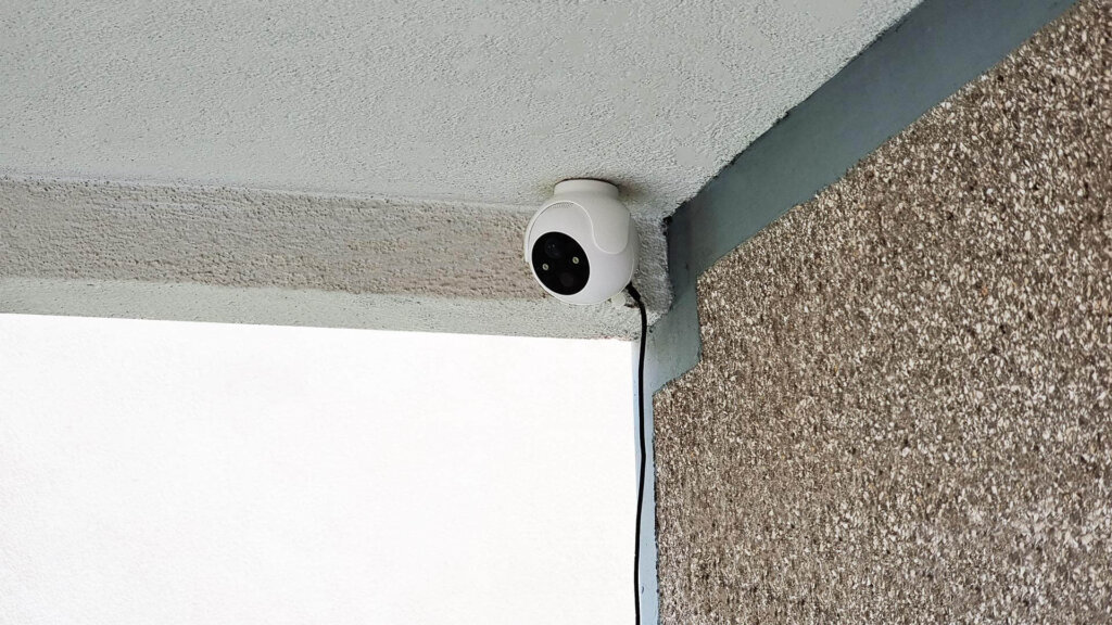 SwitchBot Outdoor Spotlight Camera Installed Above Door in Corner
